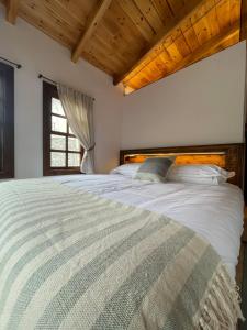 uma cama grande num quarto com uma janela em N'Gorice em Berat