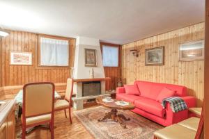 a living room with a red couch and a table at B&B San Rocco in Capo di Ponte