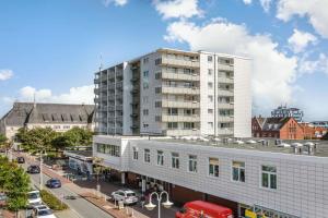 a large white building on a city street with cars at Hanseatenhaus_ Whg_ 84 _Meerblick_ in Westerland (Sylt) +25 photos