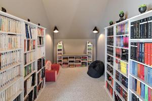 eine Bibliothek mit mehreren Bücherregalen in der Unterkunft La Coquelière - Belle maison pour 5 in Putanges