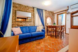 a living room with a blue couch and a table at Apartments Casa Rubeus Rovinj in Rovinj
