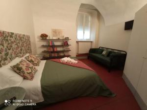 1 dormitorio con 1 cama y 1 sofá verde en Luisa in Palazzo Bianchi, en Parma