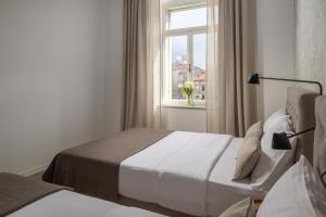 a hotel room with two beds and a window at Apartment Centro Pola in Pula