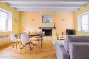 ein Wohnzimmer mit einem Tisch, einem Sofa und einem Kamin in der Unterkunft Seabird - Belle maison pour 8 in Camoël