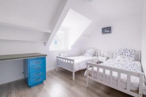 Zimmer mit 2 Kinderbetten und einem Schreibtisch mit 2 Betten in der Unterkunft Seabird - Belle maison pour 8 in Camoël
