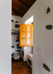 einen Flur in einem Haus mit einem Zimmer mit Fenster in der Unterkunft Casa Rural Los Chicos Hermigua in Hermigua