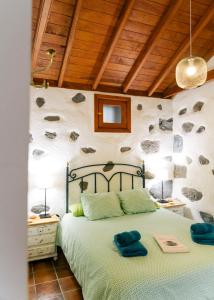 1 dormitorio con 1 cama con 2 toallas azules en Casa Rural Los Chicos Hermigua, en Hermigua
