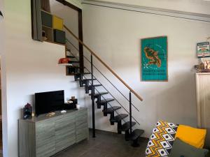 sala de estar con escalera y TV en Studioloc'Martinique, en Les Trois-Îlets