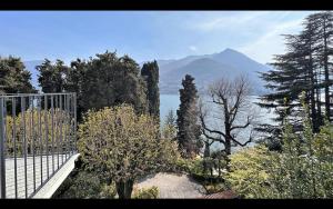 a gate with trees and a mountain in the background at Villa Sole Carate Urio – Lake Como in Carate Urio