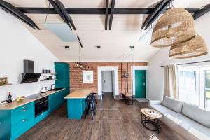 a kitchen and living room with blue cabinets and a couch at Kadyny Apartments 37B in Kadyny