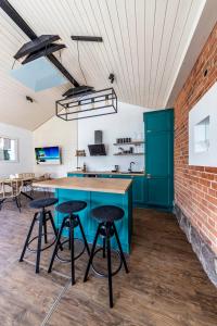 an open kitchen with a blue island and bar stools at Kadyny Apartments 37B in Kadyny