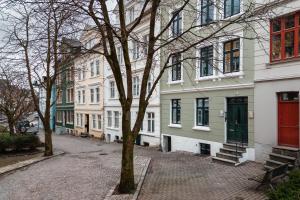 um grupo de edifícios numa rua com uma árvore em Meltzers Apartments em Bergen