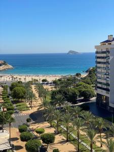 Blick auf einen Strand mit Palmen und ein Gebäude in der Unterkunft EDIFICIO CORUÑA CALA DE FINESTRAT. Luxury apt. in Benidorm