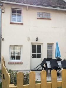 a house with a table and chairs in front of it at Calme et verdure en plein coeur d Illiers Combray in Illiers