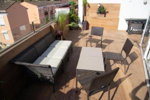 a balcony with a bench and tables and chairs at Puerta Palma con vistas únicas y aparcamiento in Badajoz