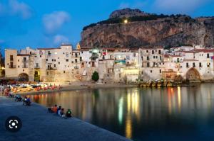 Un groupe de personnes assises au bord d'une masse d'eau dans l'établissement Casa Marina, La Terrazza Sul Mare, à Cefalù
