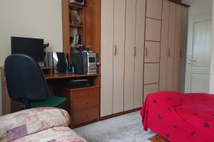 1 dormitorio con escritorio, ordenador y cama en Apartment 4 Kullat en Prizren