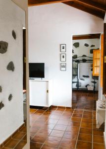 a living room with a television and a tiled floor at Casa Rural Los Chicos Hermigua in Hermigua