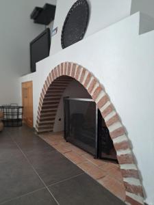 una chimenea de ladrillo en una habitación con un reloj en la pared en Villa Caballero, en Alfundão