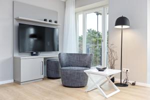 salon z telewizorem, krzesłem i stołem w obiekcie Strandresidenzen Strandresidenzen Haus Dänholm 3 3 w mieście Binz