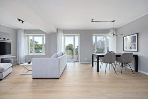 een witte woonkamer met een tafel en stoelen bij Strandresidenzen Strandresidenzen Haus Dänholm 3 4 in Binz