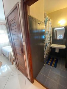 uma casa de banho com um chuveiro e um lavatório. em IVATO HOTEL - HOTEL IVATO Airport em Antananarivo