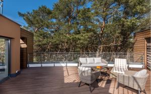 eine Terrasse mit einem Sofa, Stühlen und einem Tisch in der Unterkunft 2HomeRent Bosque in Rogowo