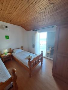 een slaapkamer met een bed en een groot raam bij Bradley apartmants HR in Račišće
