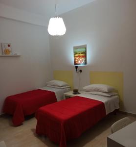 Cette chambre comprend 2 lits avec des draps rouges. dans l'établissement Casa vacanza Melf, à Terrasini