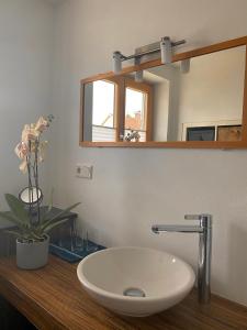 La salle de bains est pourvue d'un lavabo blanc et d'un miroir. dans l'établissement Charmante Ferienwohnung, à Kaufbeuren
