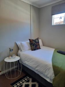 a small bedroom with a bed and a side table at Little Milner Cottage in Queenstown