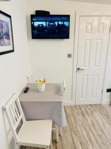 a dining room table and chairs with a television on the wall at Lodge Apartment in Dublin