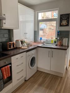 a kitchen with a sink and a washing machine at Cosy 2 bed terraced house in Conwy in Conwy