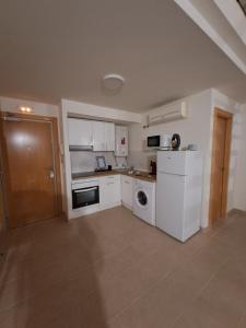 a kitchen with white cabinets and a washer and dryer at Acogedor loftcon garaje a 10min del aeropuerto in Madrid