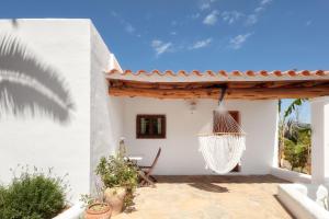 um pátio com uma rede de descanso suspensa numa casa branca em CAN TEO - Holiday Villa in Ibiza em Ibiza