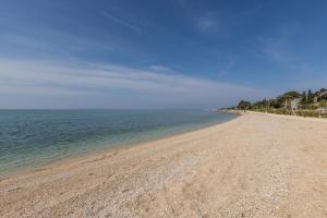 a sandy beach with the ocean in the background at Seaside Sanctuary - Modern 3 Bedroom and 3 Bathroom Apartment 60m from Beach in Novalja