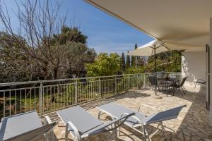 a patio with a table and chairs and an umbrella at Seaside Sanctuary - Modern 3 Bedroom and 3 Bathroom Apartment 60m from Beach in Novalja