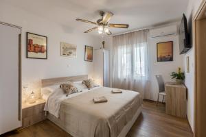 a bedroom with a bed and a ceiling fan at Seaside Sanctuary - Modern 3 Bedroom and 3 Bathroom Apartment 60m from Beach in Novalja