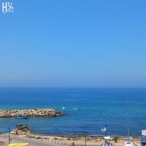 a view of the ocean with a beach and a boat at מלון בוטיק H34 in Nahariyya