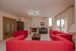 una sala de estar con sofás rojos y un piano en Villa Carrera 4 Bedrooms, en Fanals d'Aro