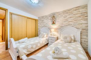 a bedroom with two beds and a brick wall at Ideal Property Mallorca - Can Caragol Inca in Inca
