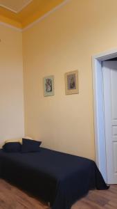 sypialnia z łóżkiem i 2 zdjęciami na ścianie w obiekcie Apartmán U kolonády w Mariańskich Łaźniach