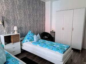 een slaapkamer met een bed met blauwe kussens en een kast bij Ferienwohnung Talblume in Marl