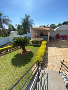 a house with a palm tree in the yard at Hotel Boituva Inn - Your Hotel in Boituva