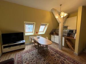 a living room with a wooden table and a kitchen at Ferienwohnung - Schweriner Altstadt - FeWo 4 in Schwerin +5 photos