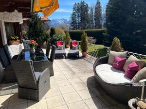 un patio con divano, tavolo e sedie. di Alpen Suite Tegernsee - große Sonnenterasse und idyllischer Garten a Bad Wiessee