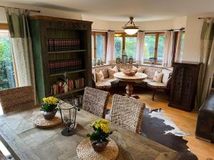 a living room with a table and chairs at Alpen Suite Tegernsee - große Sonnenterasse und idyllischer Garten in Bad Wiessee