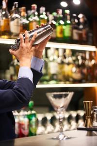 a man holding up a drink bottle in a bar at Silken Ramblas in Barcelona