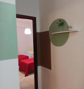 Cette chambre comprend un miroir et un lit rouge. dans l'établissement Casa vacanza Melf, à Terrasini