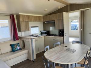 uma cozinha e sala de jantar com uma mesa numa caravana em Camping De Collignon em Cherbourg en Cotentin